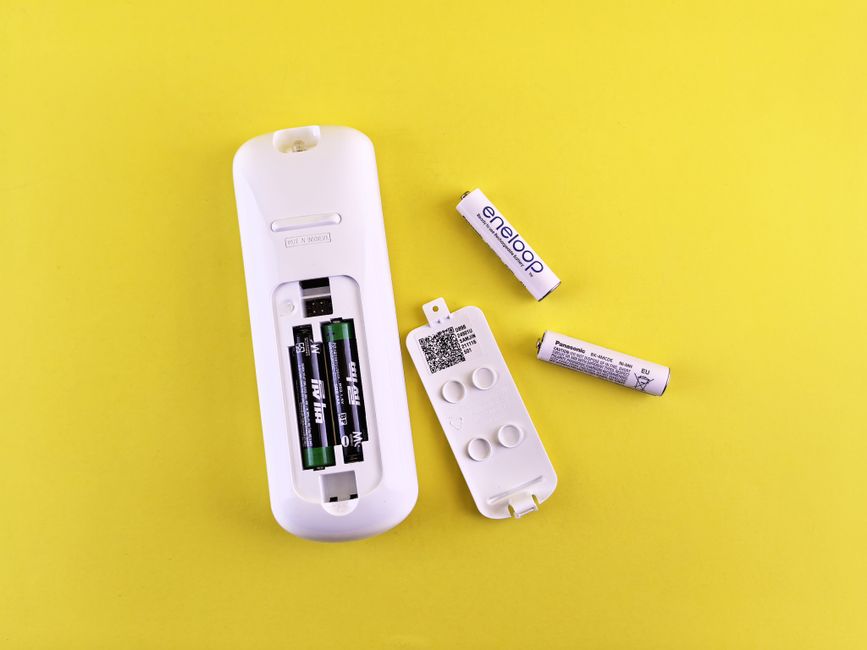 リモコンの電池ぶたを開けて充電池を入れ替えているところ