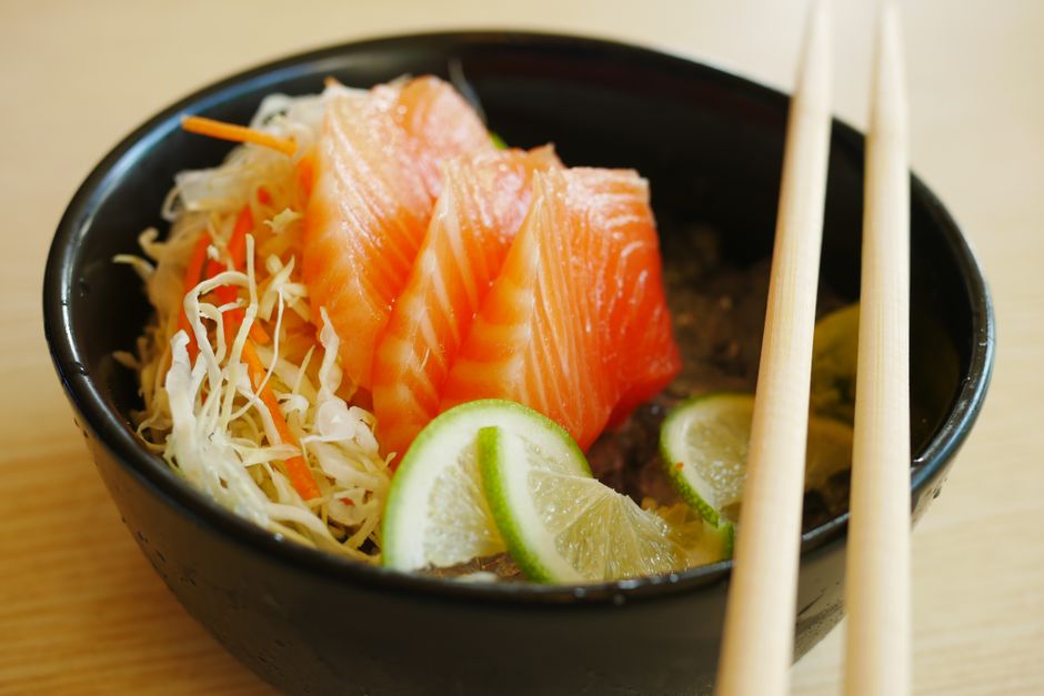 サーモンの刺身に輪切りの青い柑橘を添えた丼と箸