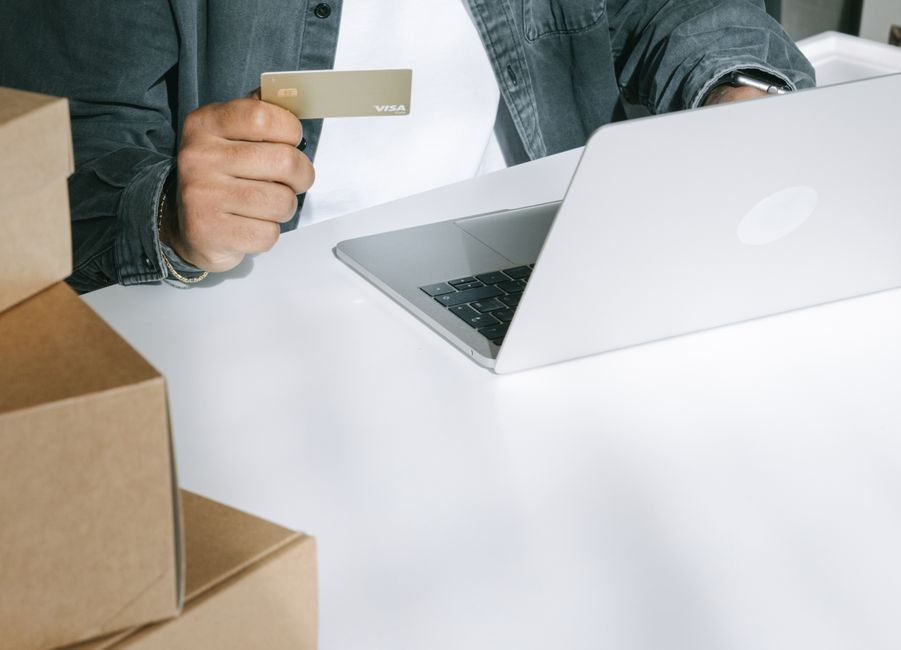 ノートパソコンとカードで通販を利用する様子