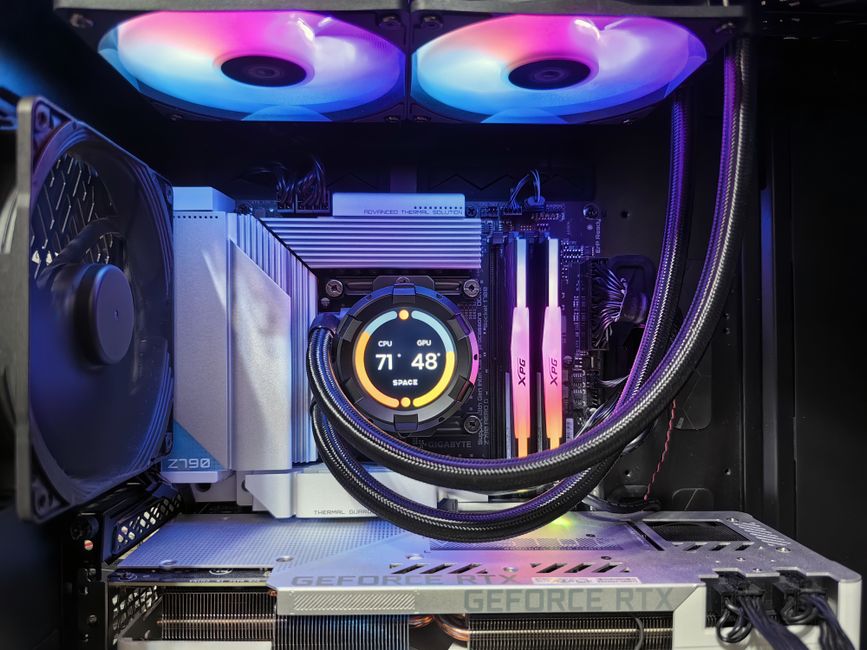 光るケースファンと簡易水冷クーラーの下に大型グラフィックボードを搭載したゲーミングPCの内部